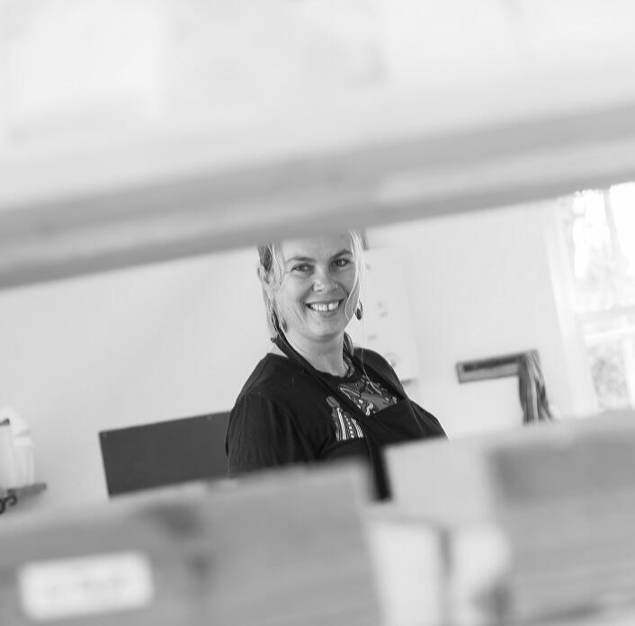 Woman looking between soap trays in her workshop