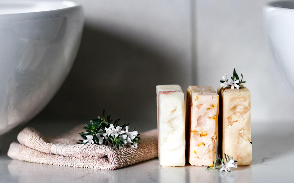 row of handmade soaps next to a towel in a cozy bathroom