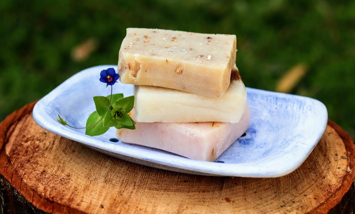 row of handmade soaps next to a towel in a cozy bathroom